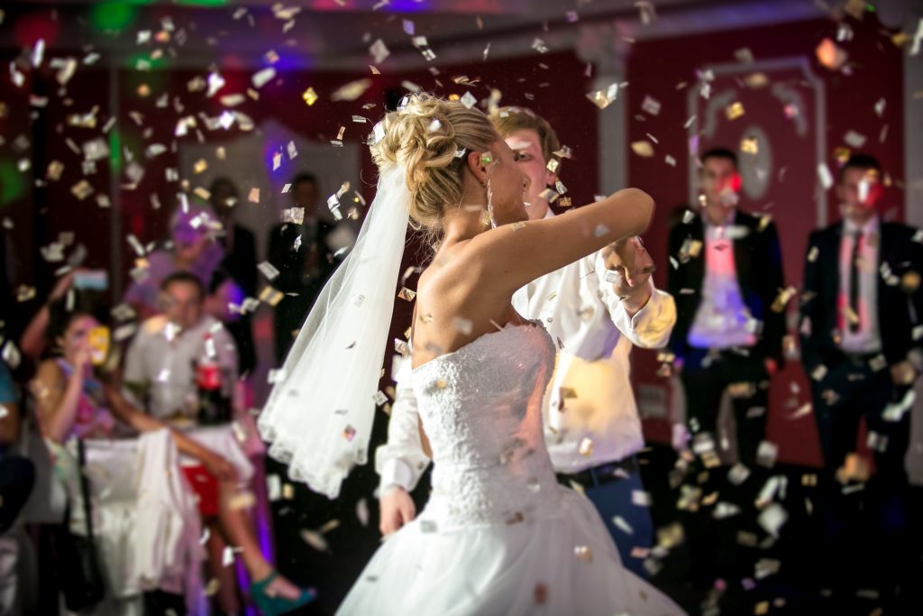 Wedding DJ - Beautiful blonde bride dancing at restaurant in flying confetti